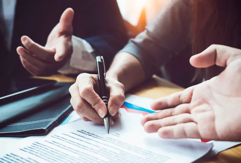 Signing documents during a business meeting.