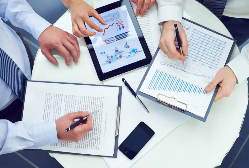 Business meeting with documents and tablet.