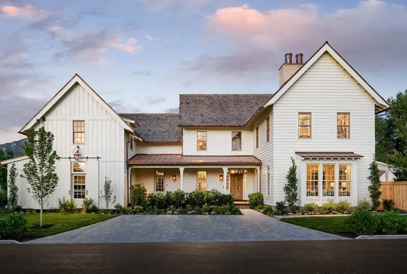 Large modern farmhouse with landscaped yard.