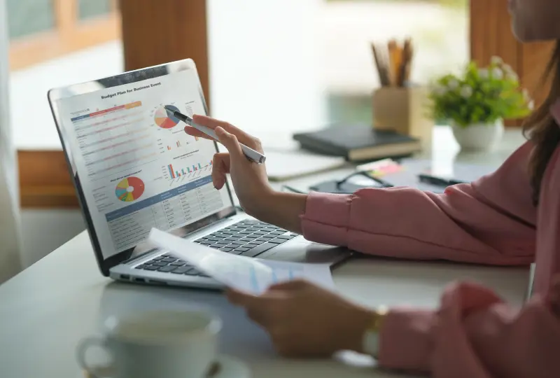 Person analyzing charts on a laptop screen.